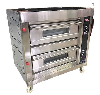 Das Backen von rundem Kokosbrot wird mit einer großen Ofenmaschine in der Pie Long Loaf Bakery erleichtert